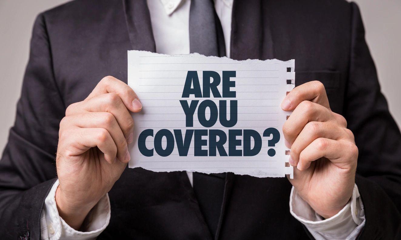 Group Benefits - Person in business suit holding sign stating "are you covered?"